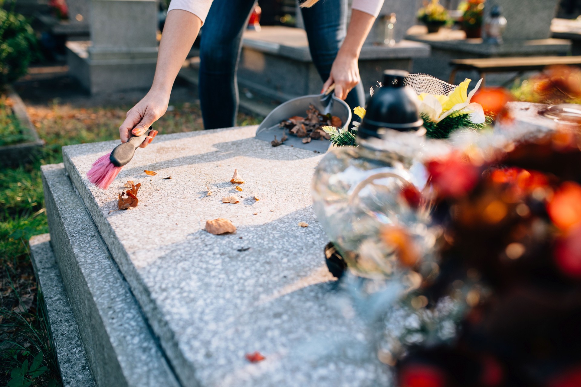Woman cleans the grave.