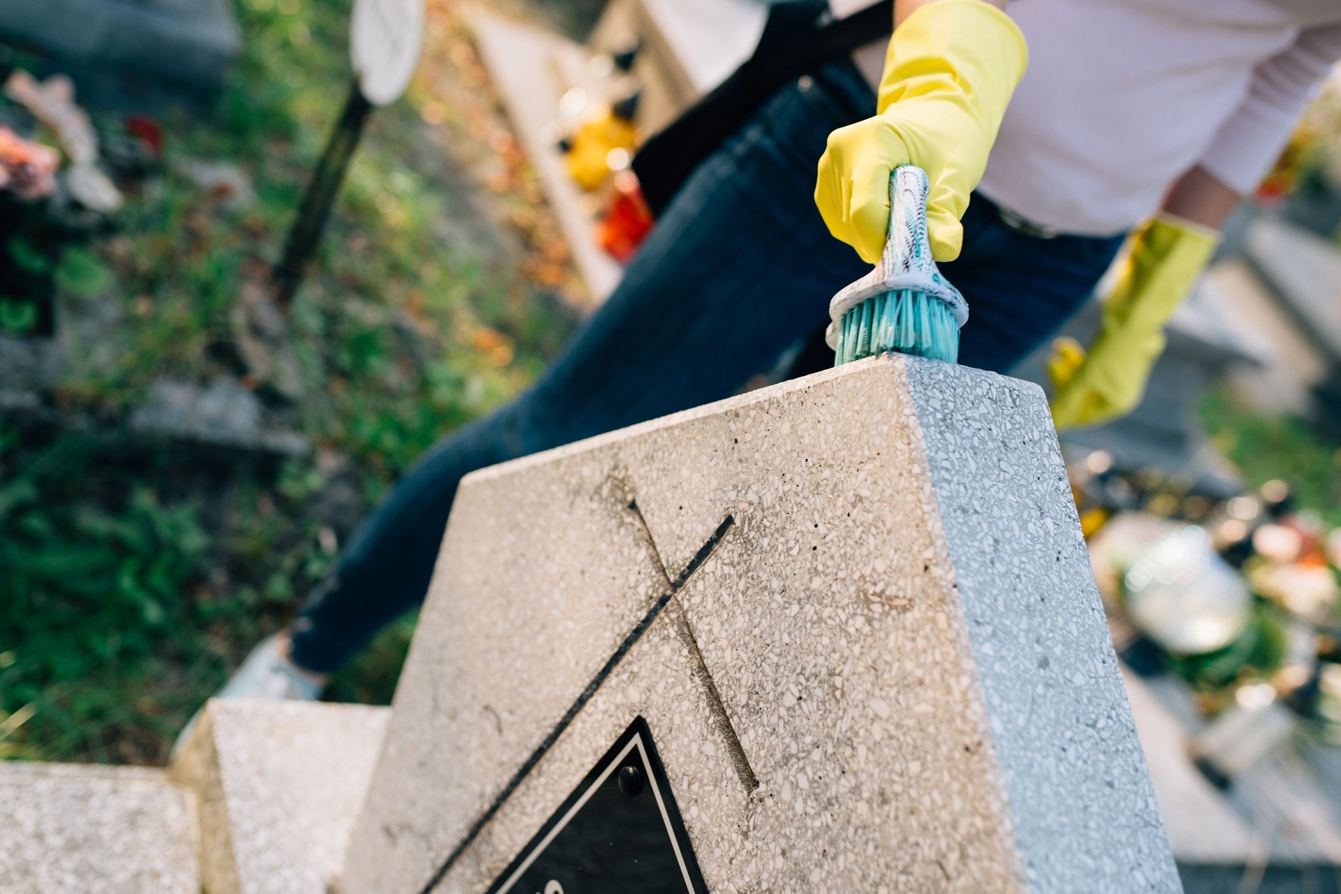 Woman cleans the grave.
